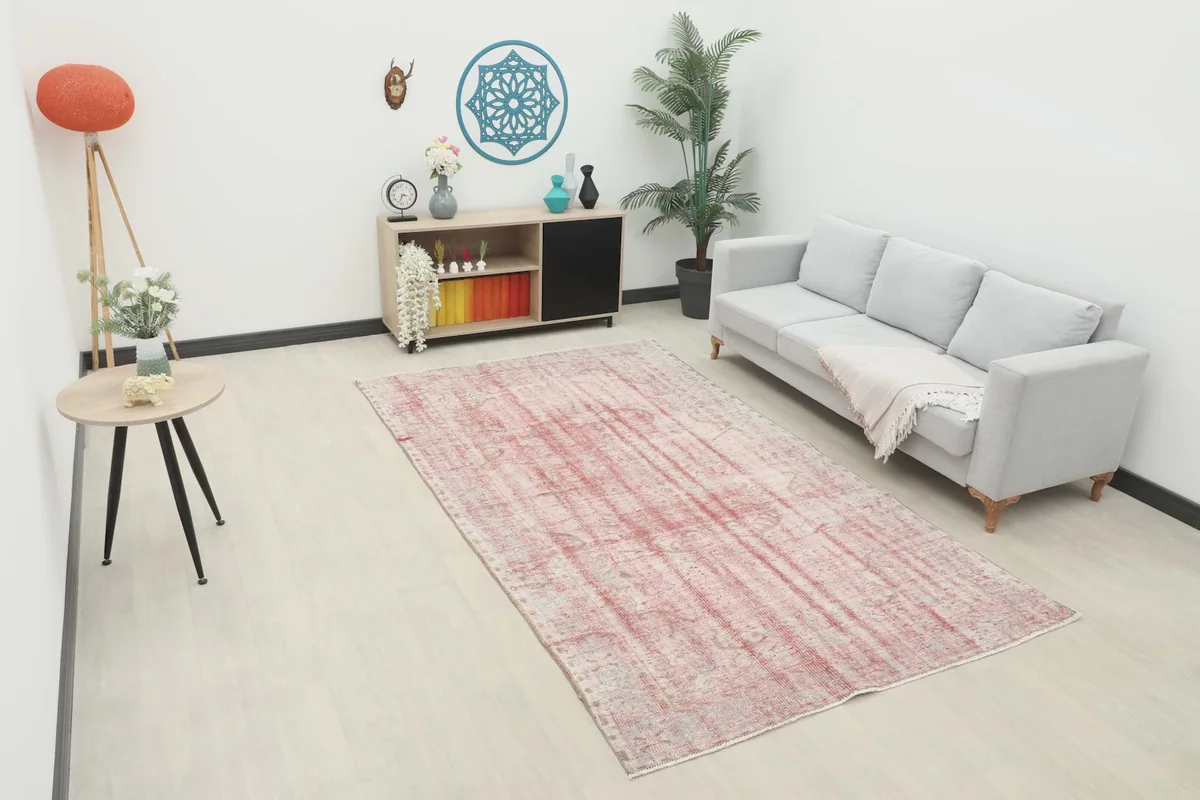 Rose and gray area rug displayed in a modern living room setting with a light gray sofa.