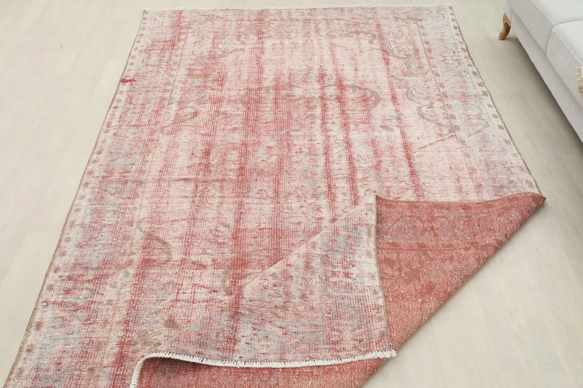 Rug with a corner folded back, illustrating the thickness and construction from pile to foundation.