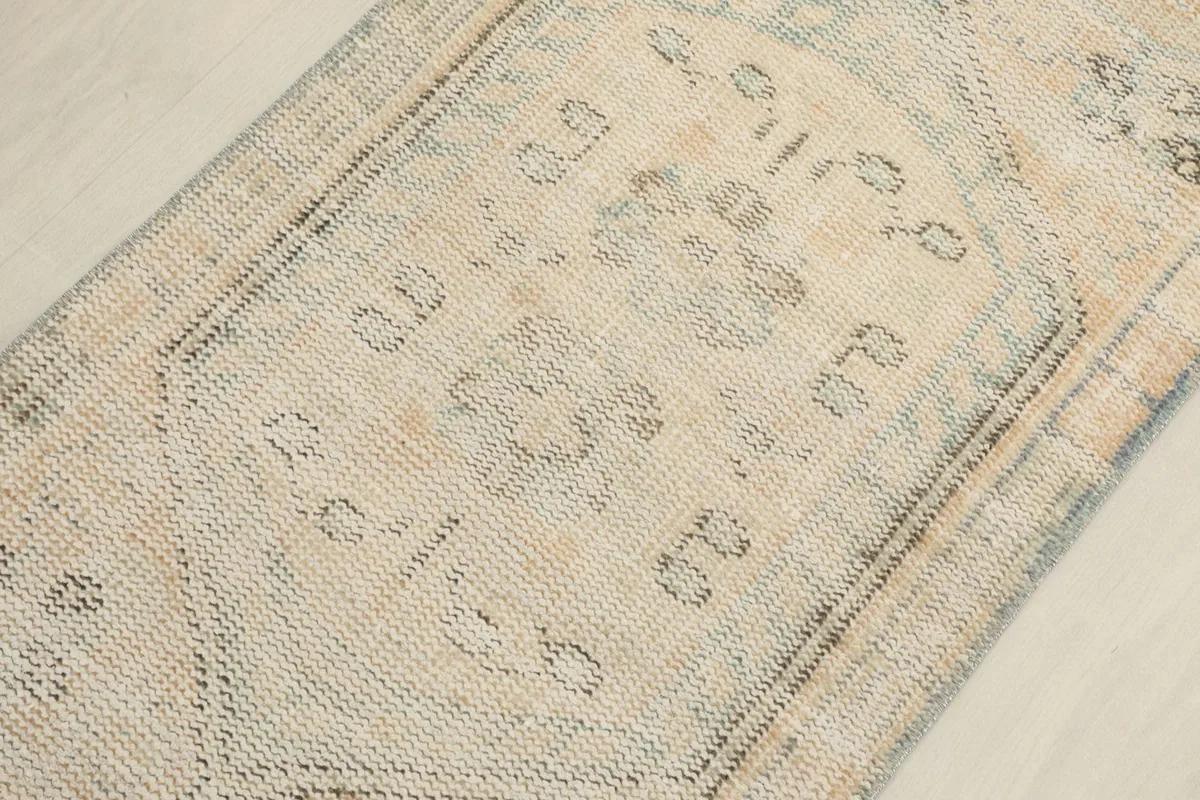 Detailed view of the central geometric motif and subtle color variations in the rug's pile