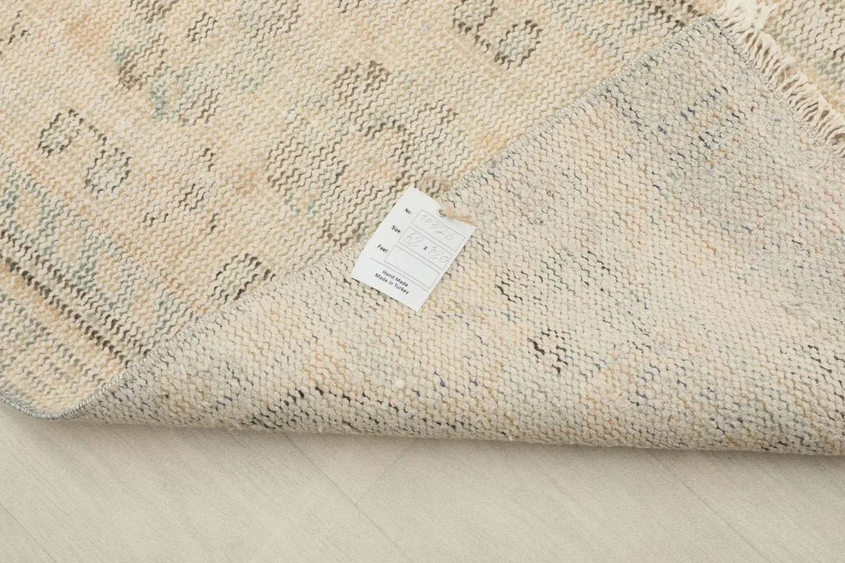 Close-up of the back of the rug, displaying the tight knotting and a product label