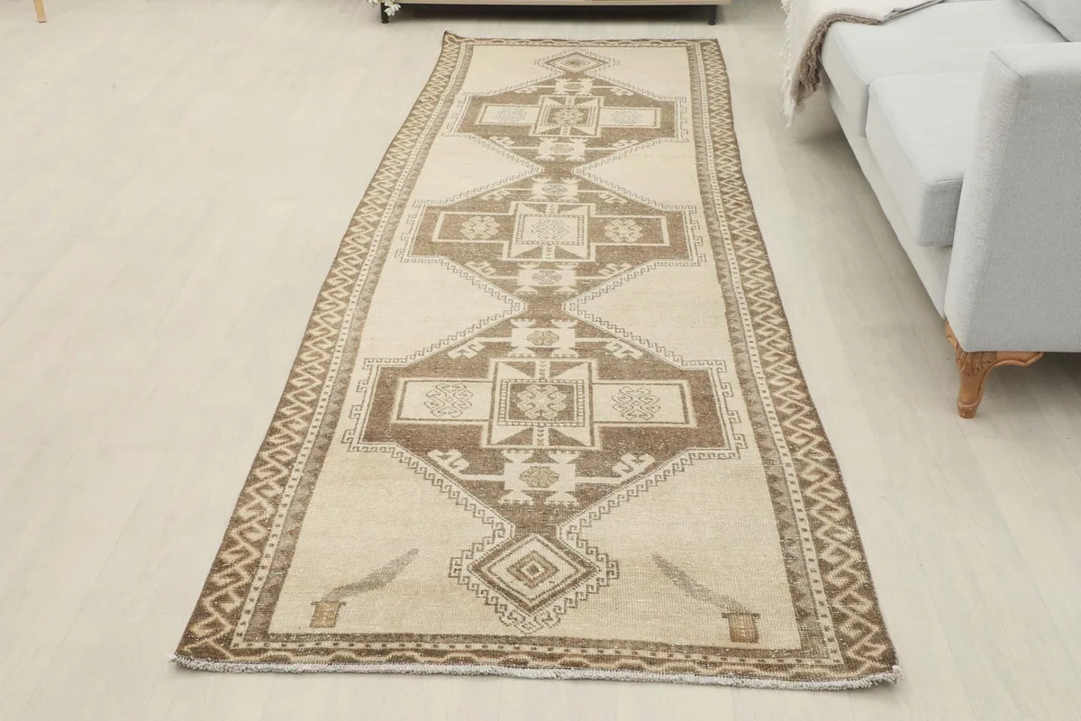 Full length view of the beige and brown runner rug laid out in a modern room setting.