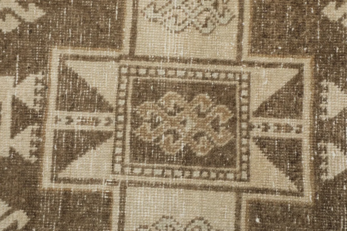 Macro detail of the hand-knotted wool pile and the texture of the geometric pattern.