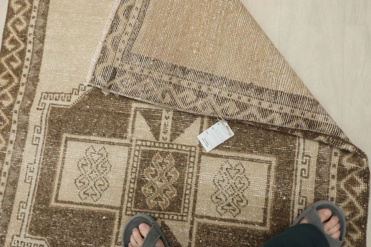 Overhead view of the rug's reverse side, revealing the hand-knotted cotton foundation.