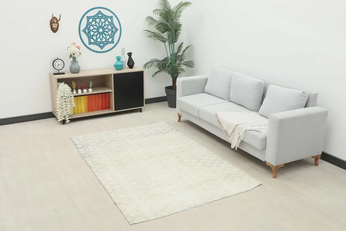 Ivory and blue vintage Anatolian rug in a living room setting with a light gray sofa