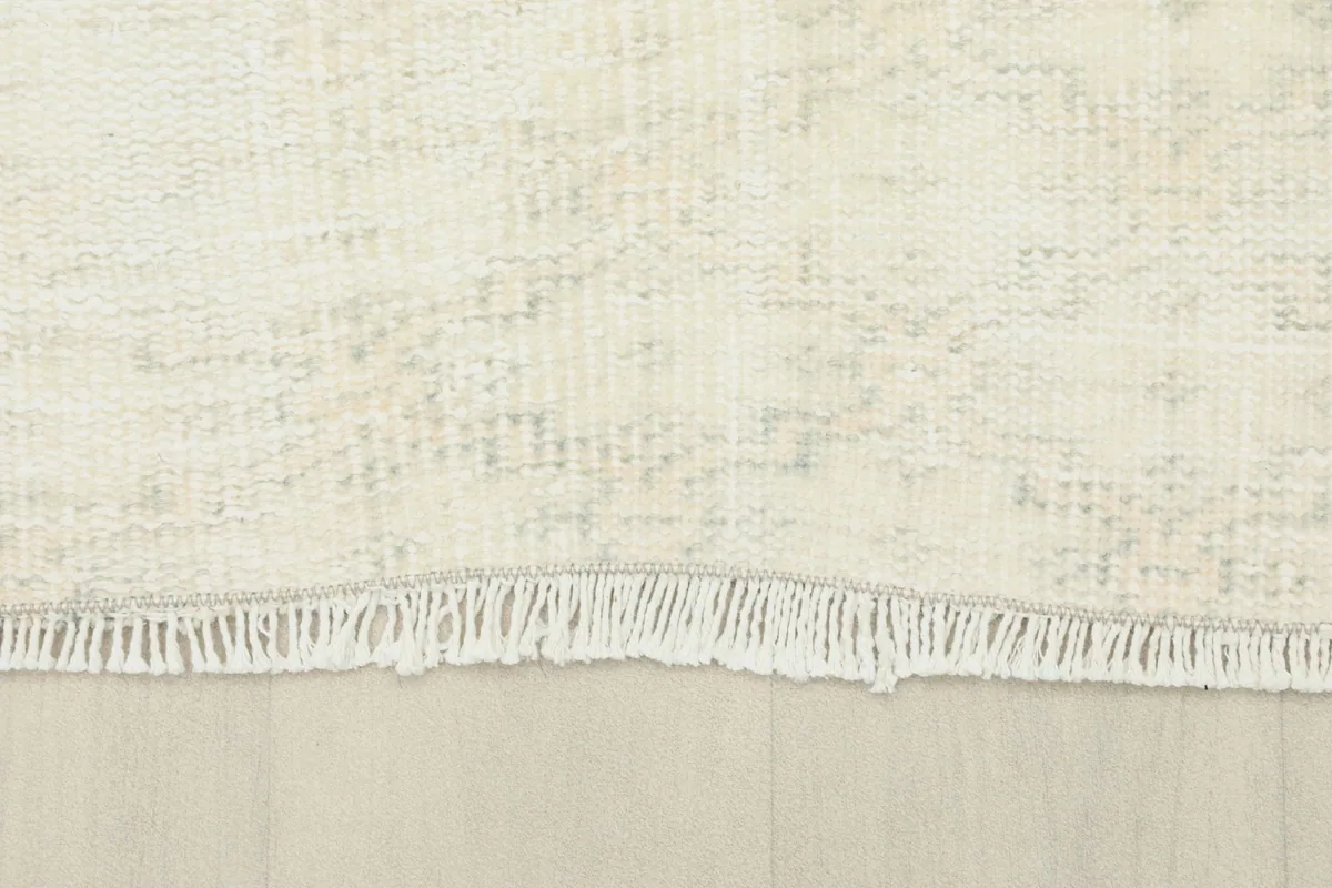 Close-up of the short, natural fringe on one end of the vintage wool rug