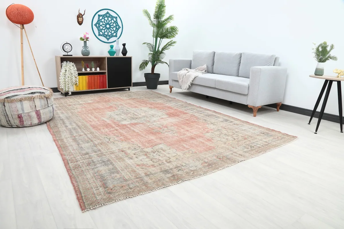 Angled view of the large rose and gray rug in a living space, highlighting its placement with furniture