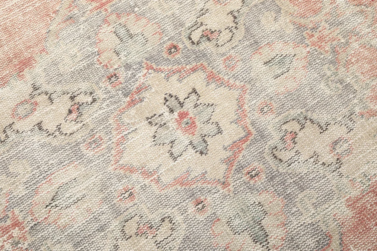 Close-up of a section of the rug, revealing the intricate hand-knotted wool pile and geometric motifs