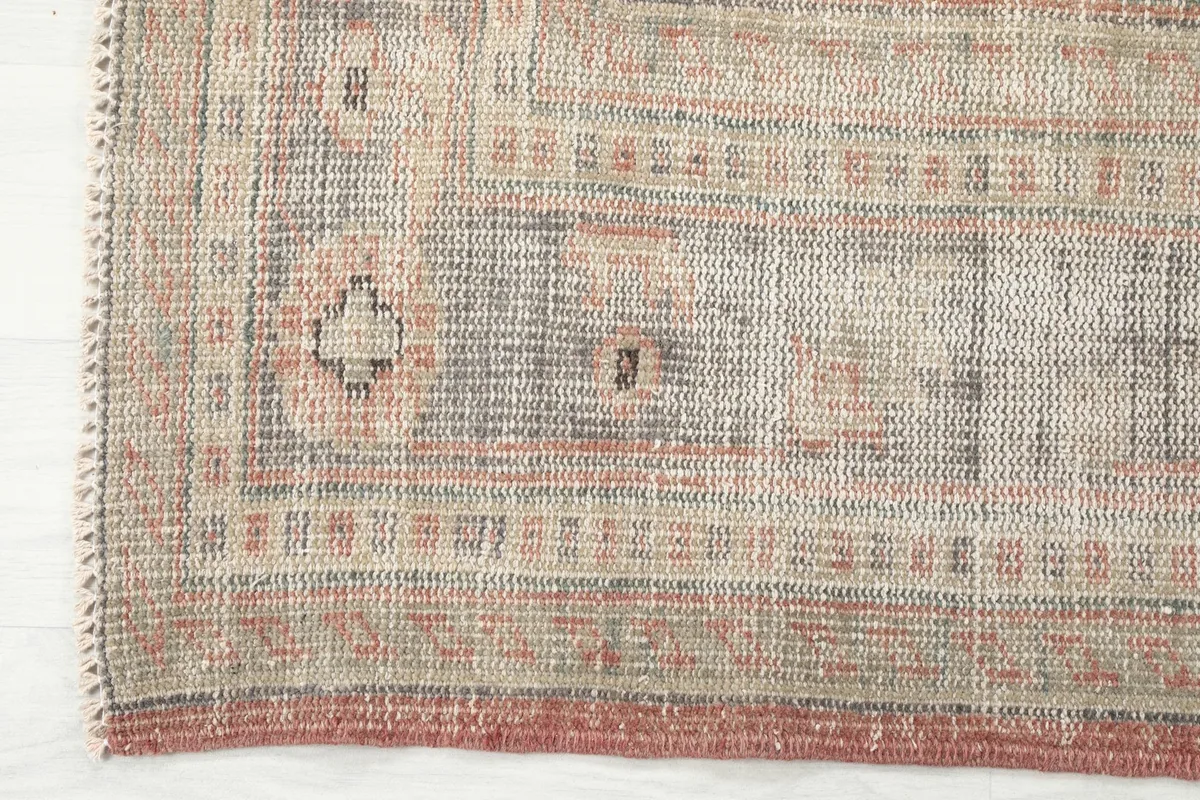 Detailed view of the rug's border pattern and edge, showing the texture and wear