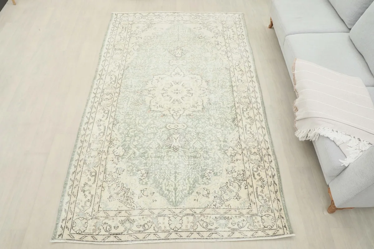 Full overhead view of the rug in a room setting, next to a light sofa, showcasing its size and presence.