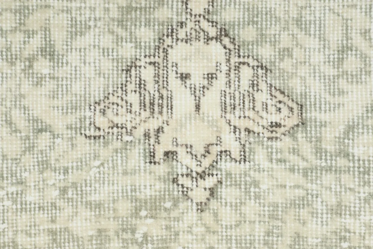 Close-up detail of a specific geometric or floral motif within the rug's field, showing texture.