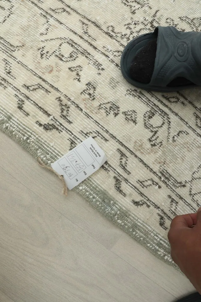 Close-up of the rug's reverse side and edge, showing the hand-knotted construction and fringe.