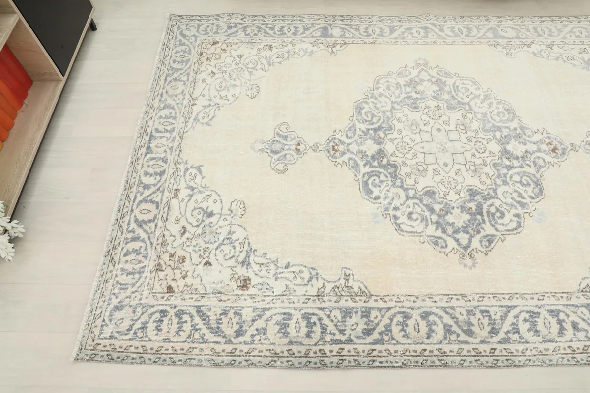 Another corner view of the rug, detailing the gray floral patterns on the ivory background.
