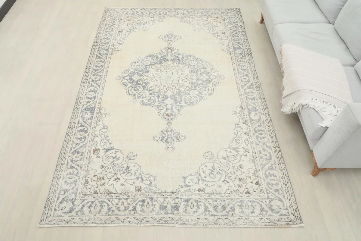 Overhead view of the ivory and gray vintage rug in a room, offering a full perspective of its size and design.