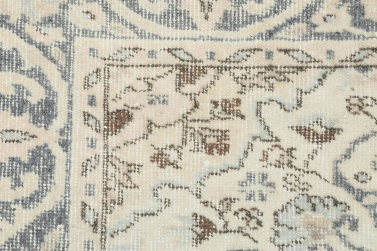 Detailed view of a corner of the rug, showing the blend of gray and brown tones in the pattern.