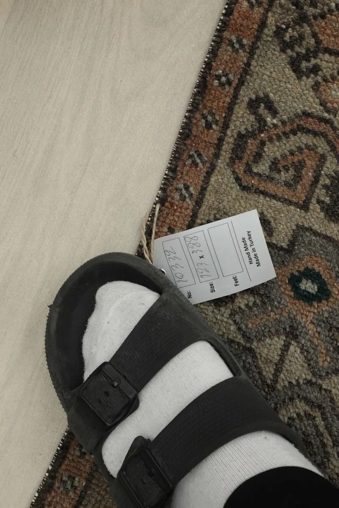 Close-up of the rug's low wool pile and a size tag, providing a sense of texture and scale.