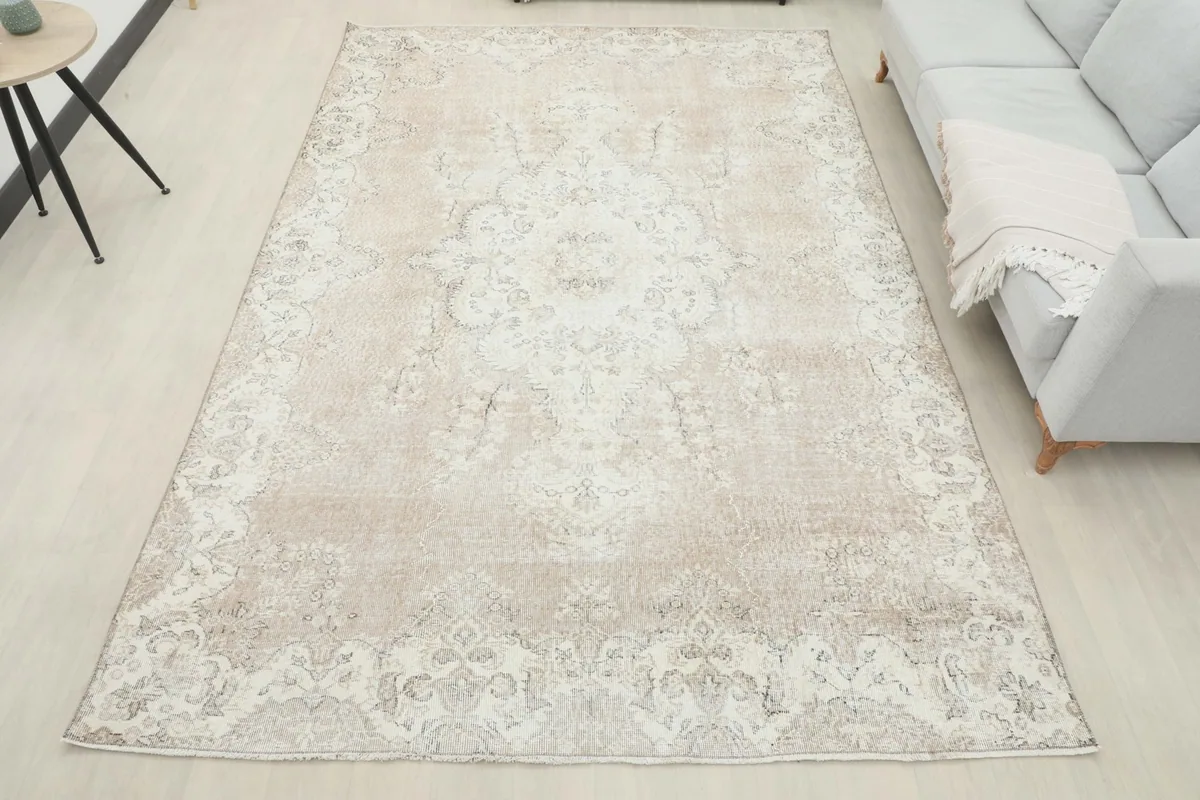 Full overhead view of the tan and ivory vintage rug in a room, offering a complete perspective of its size and design