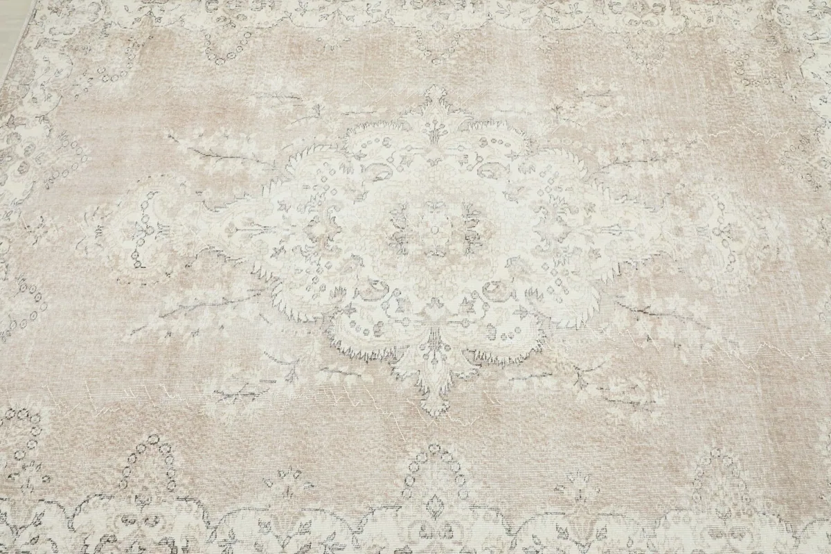 Detailed view of the central medallion design on the vintage rug, showcasing faded patterns
