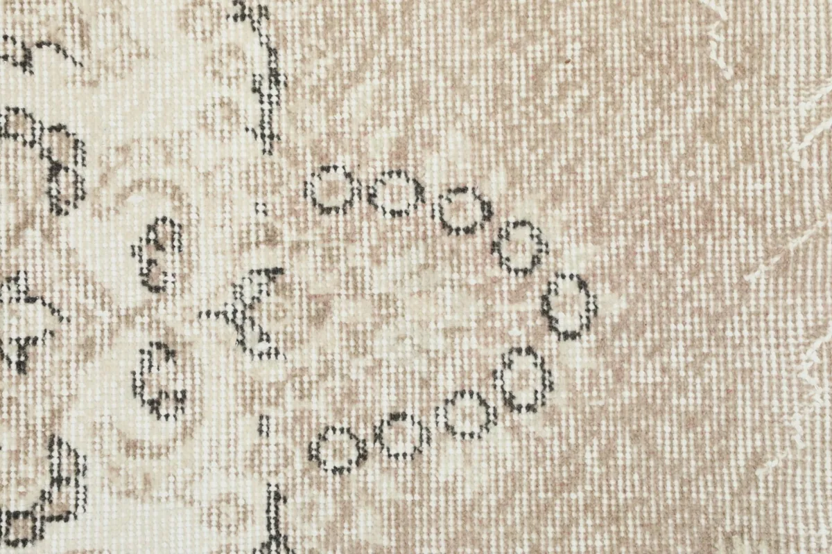 Close-up detail of the wool pile and knotting, showing some of the intricate small motifs and color variations