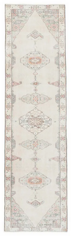 Full overhead view of a beige and rose vintage Anatolian runner rug with geometric patterns