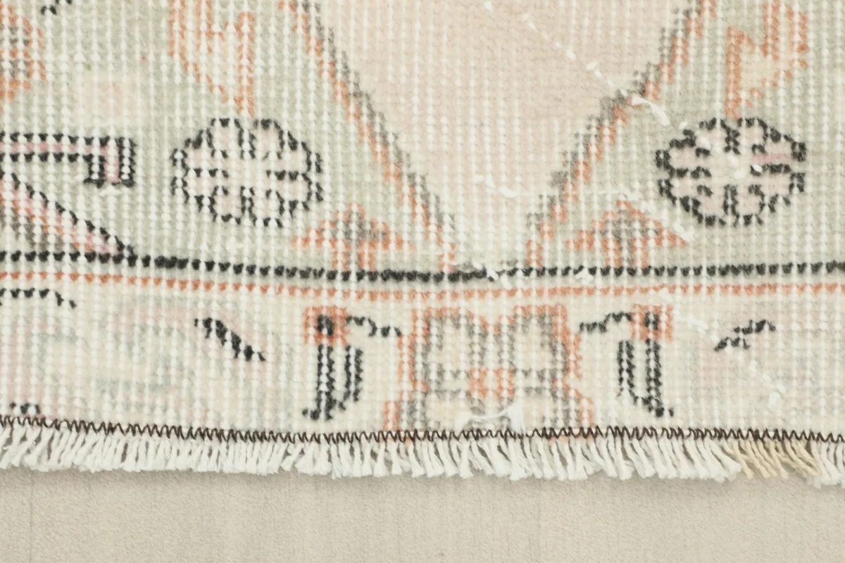 Close-up view of the low wool pile and fringe, showing the hand-knotted texture