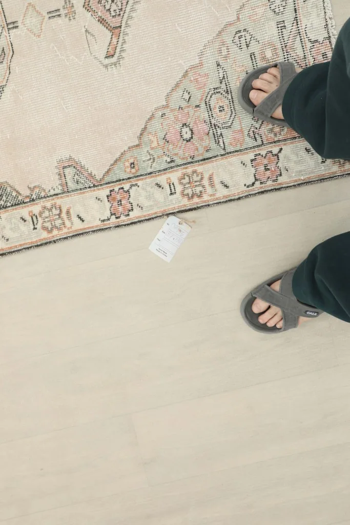 Feet in sandals next to the runner rug, indicating scale and texture