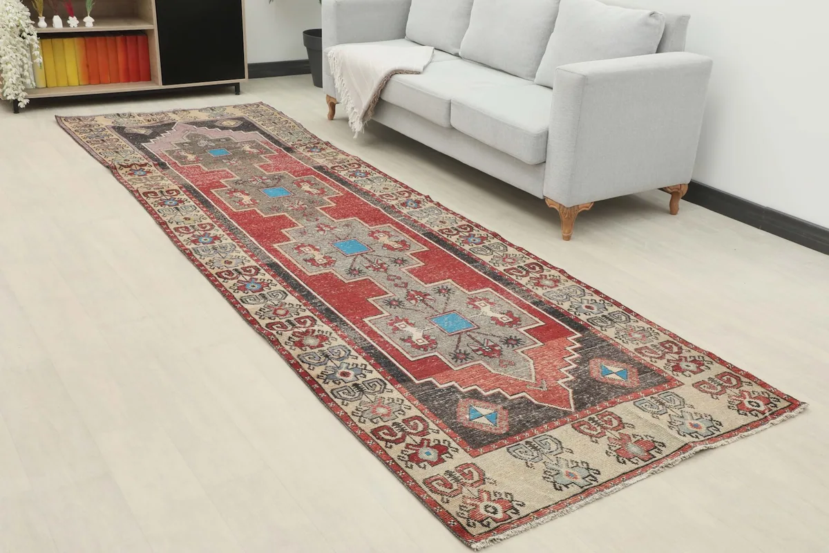 Runner rug showing its full length in a room setting, highlighting its red and gray colors