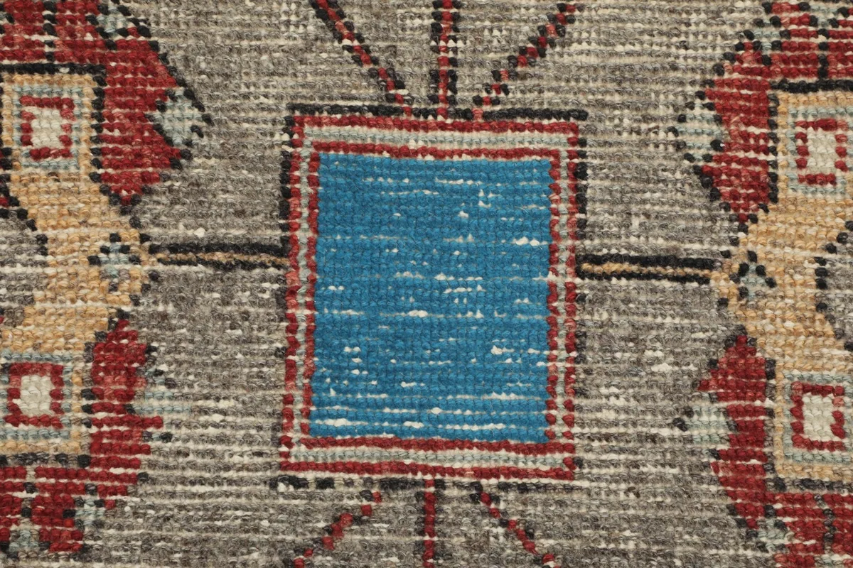 Macro shot of a blue square motif within the gray geometric design, showing wool texture