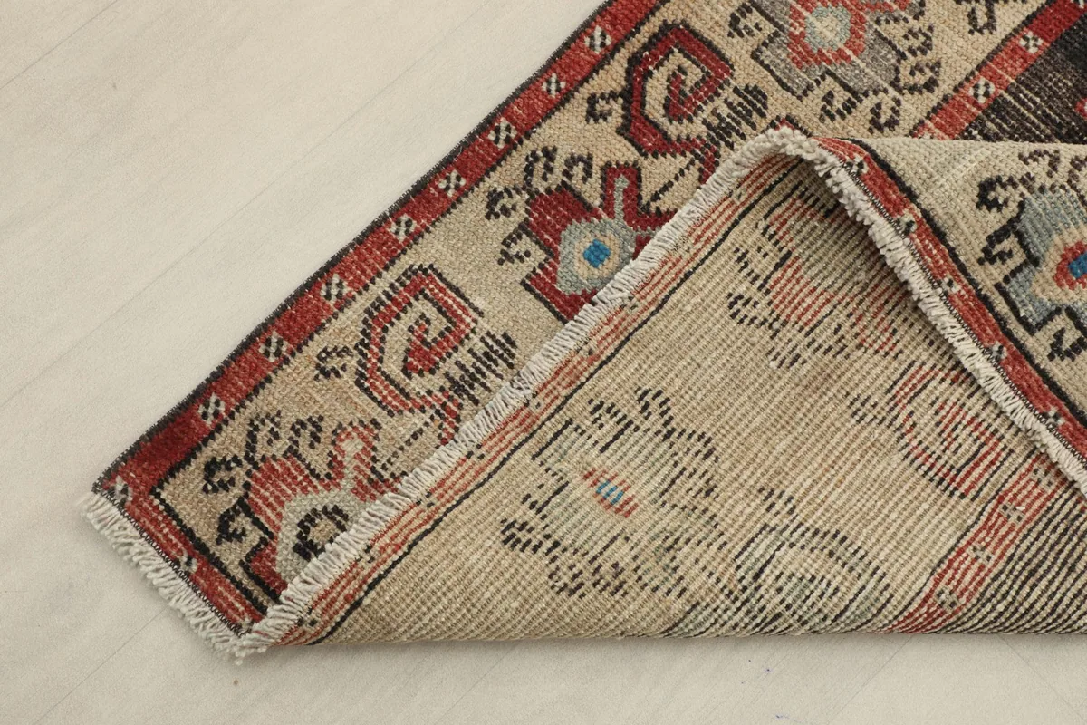 Corner of the rug folded to show the hand-knotted wool pile on cotton foundation
