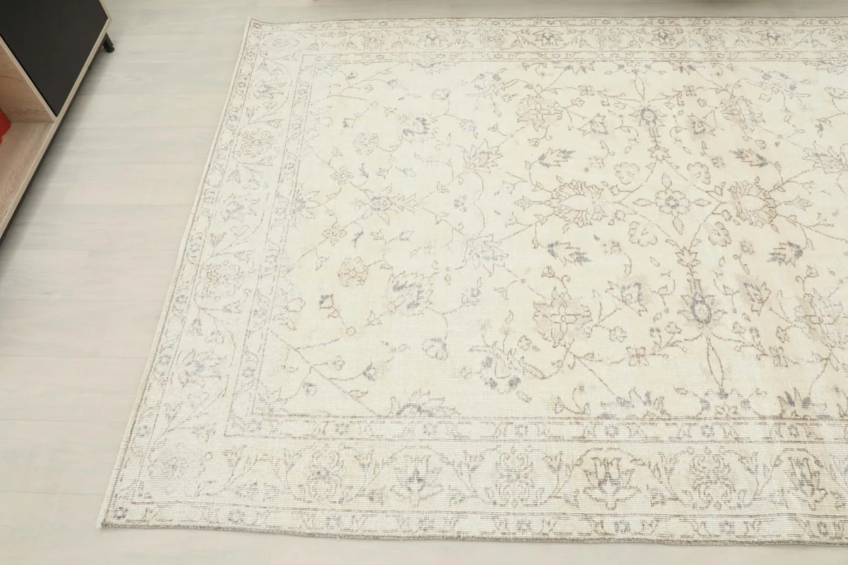 Angled shot of the rug's surface, showing the faded tan and gray motifs