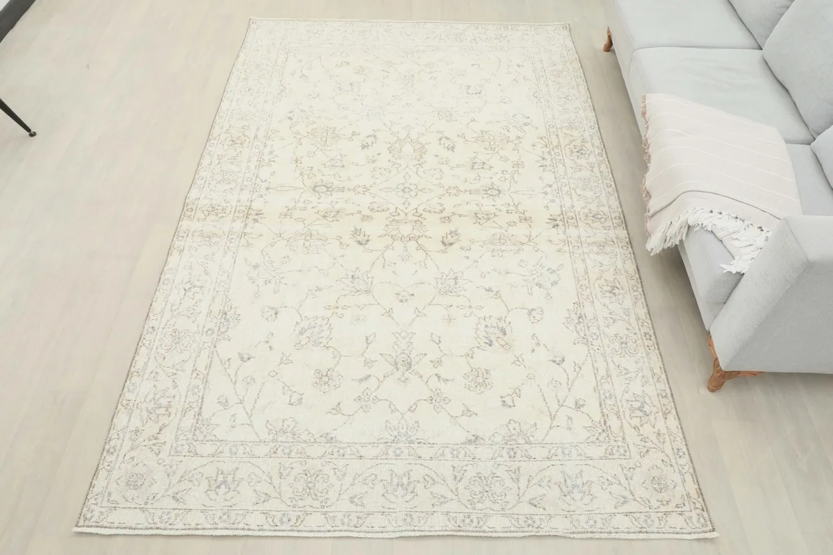 Full overhead view of the ivory rug in a spacious room setting with a sofa