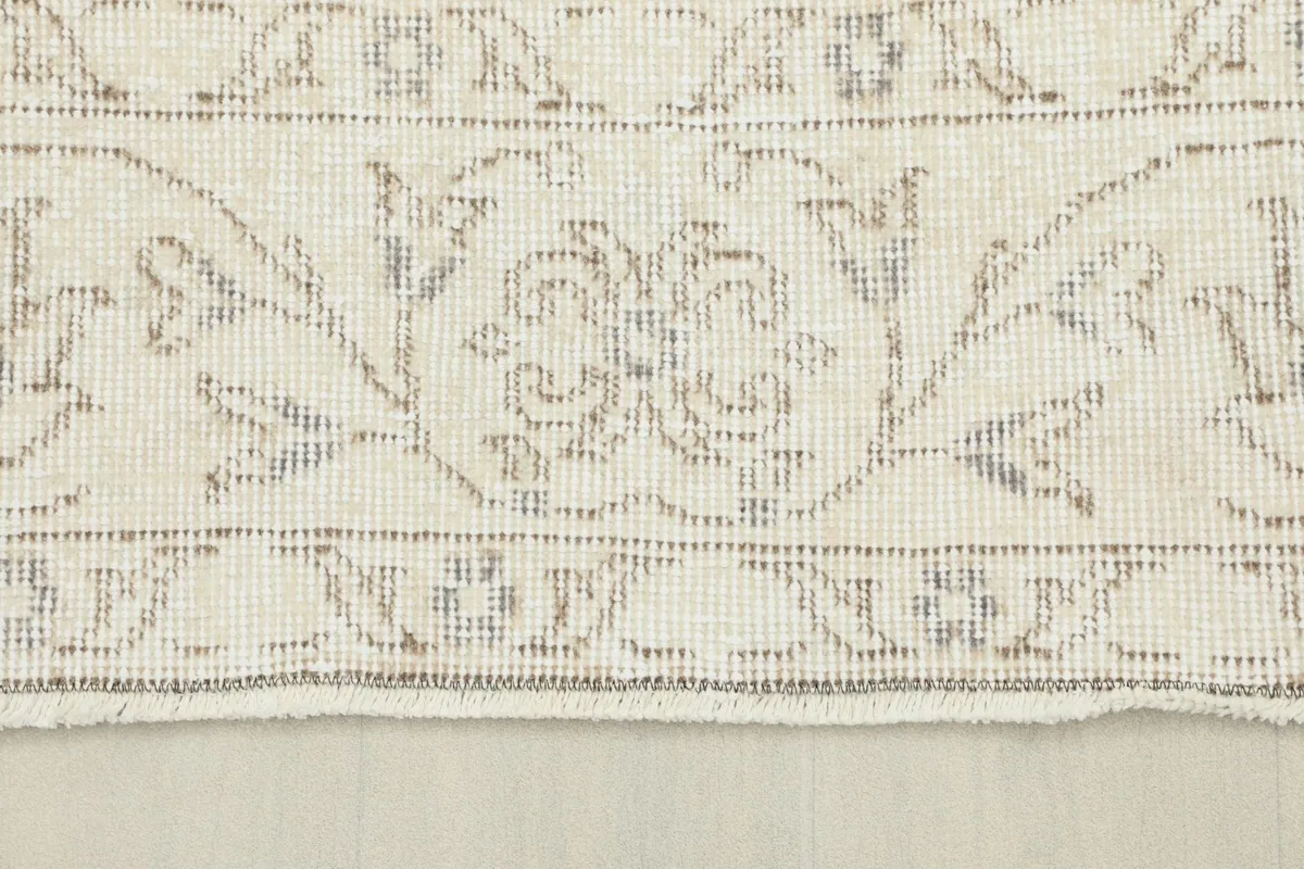 Close-up view of the intricate border design with tan and gray elements
