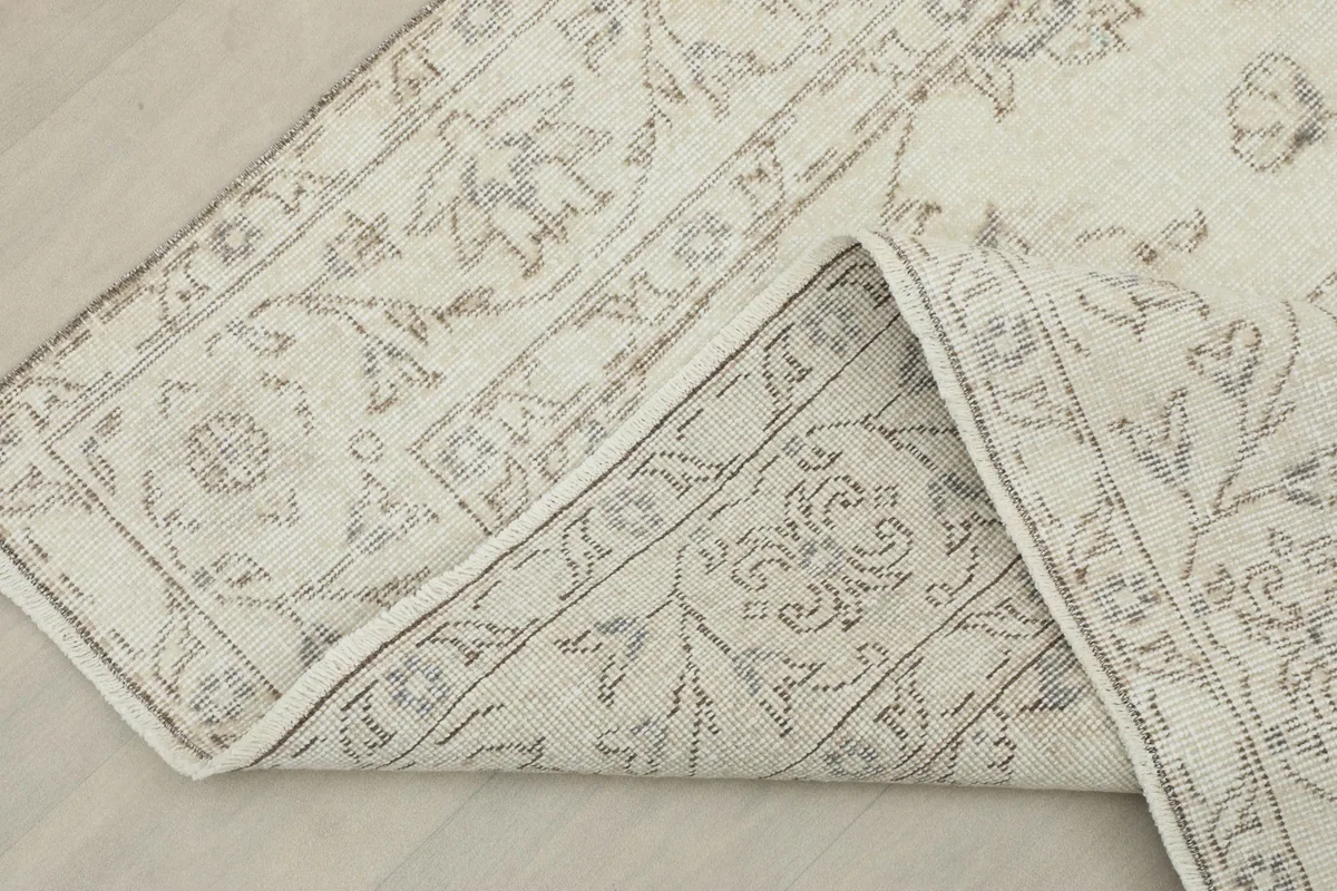 View of the rug folded to show the cotton foundation and the reverse side of the knots