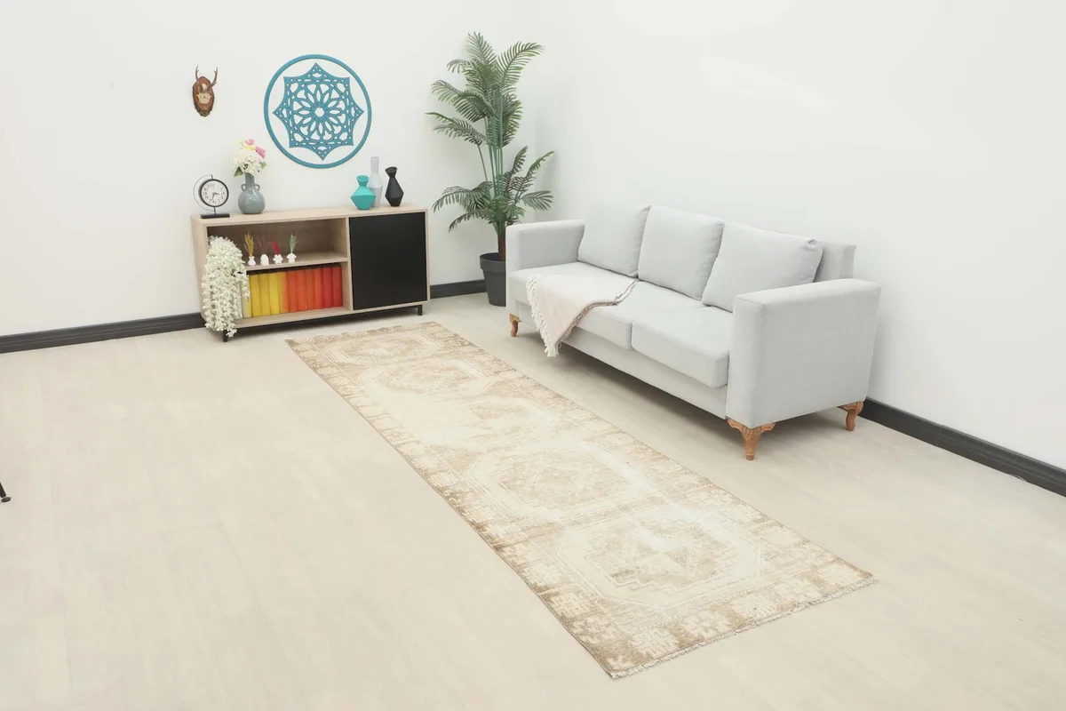 Vintage beige runner rug in a modern living room setting with a light gray sofa