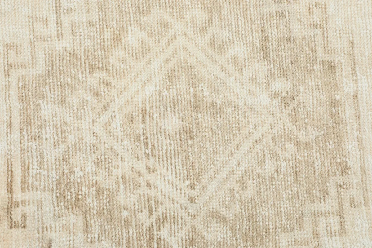 Close-up view of the low wool pile texture and subtle geometric design of the rug