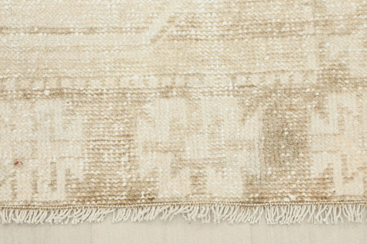 Detail of the short, natural fringe and the finished edge of the beige runner rug