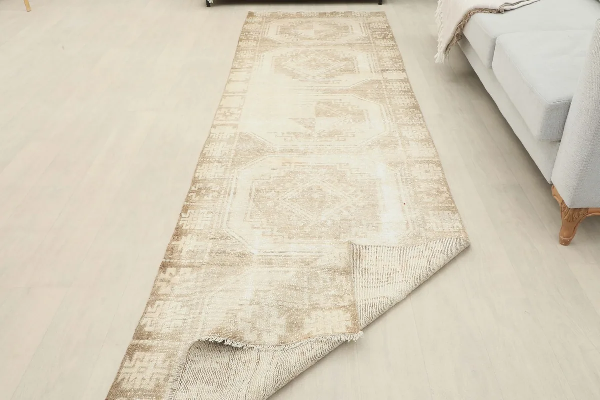 The runner rug partially folded, revealing the back and its hand-knotted construction