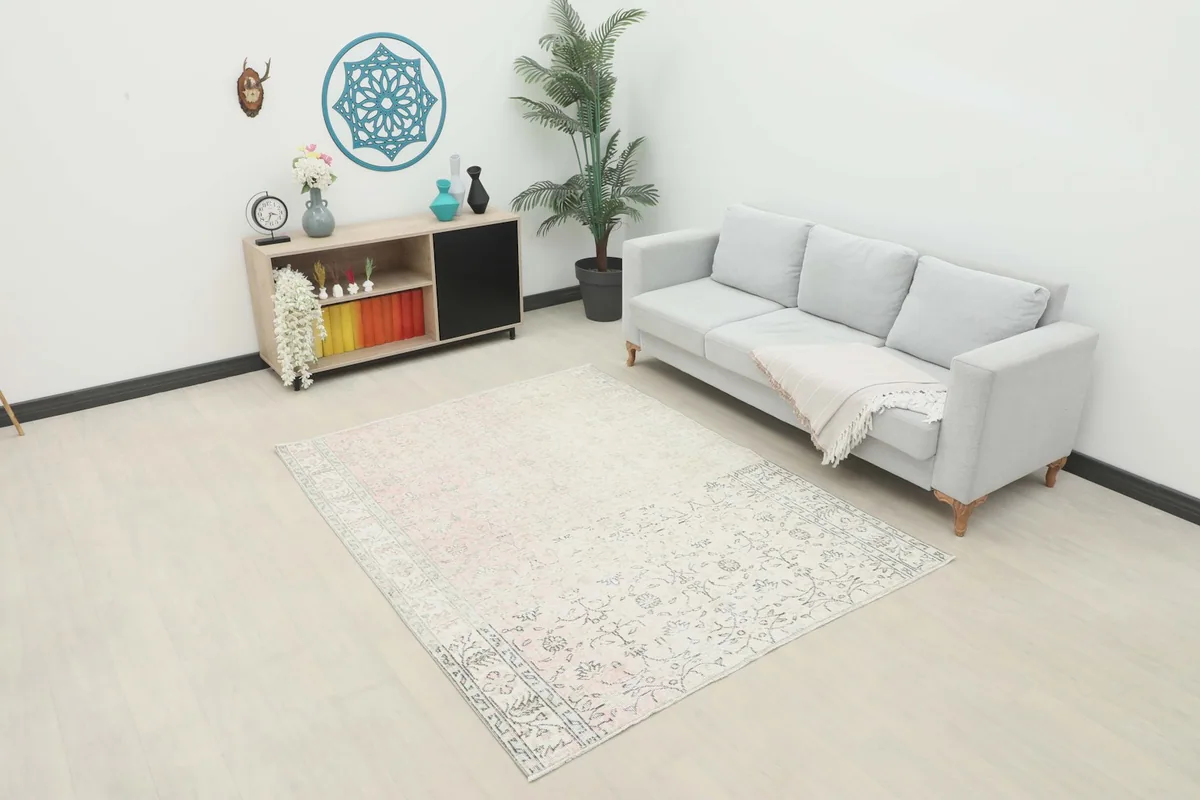 Vintage Anatolian rug with rose and ivory tones placed in a modern living room setting