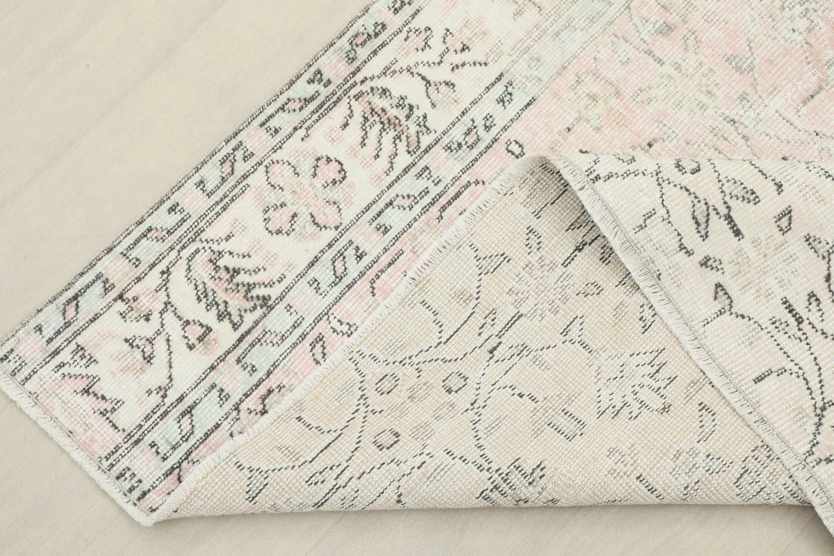 View of the rug folded back, revealing the hand-knotted cotton foundation and wool pile