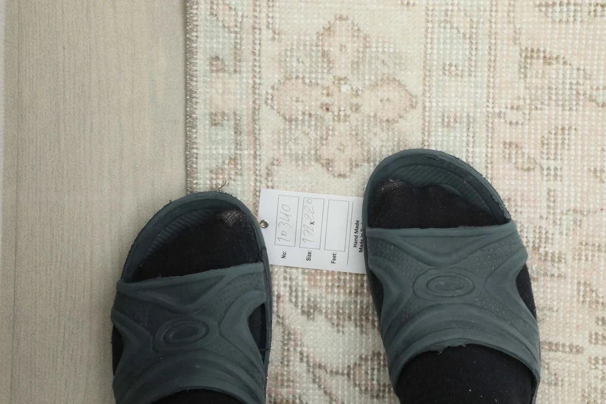 Overhead view with feet for scale, showing the texture and pattern of the rug