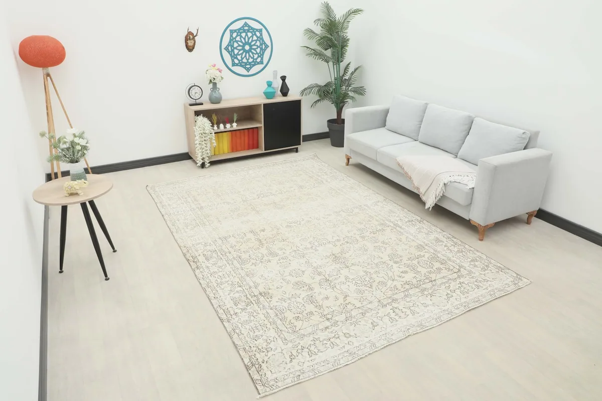 Ivory and gray vintage rug placed in a modern living room setting with a light gray couch