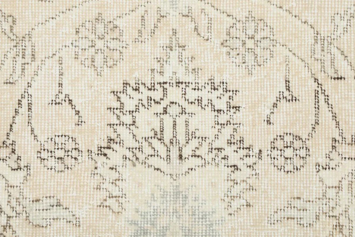 Detailed shot of a specific floral element within the rug's pattern, showing knotting