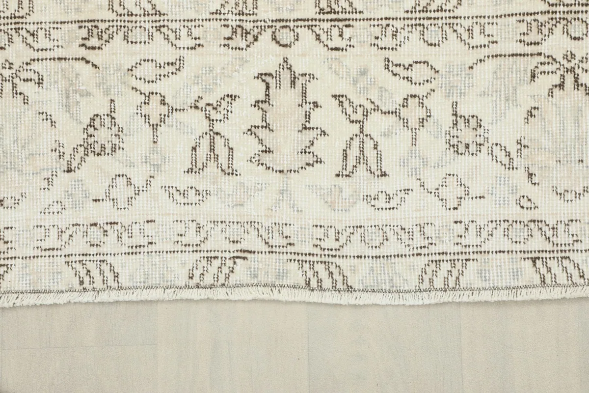 Close-up of the rug's border design, displaying the geometric and floral elements