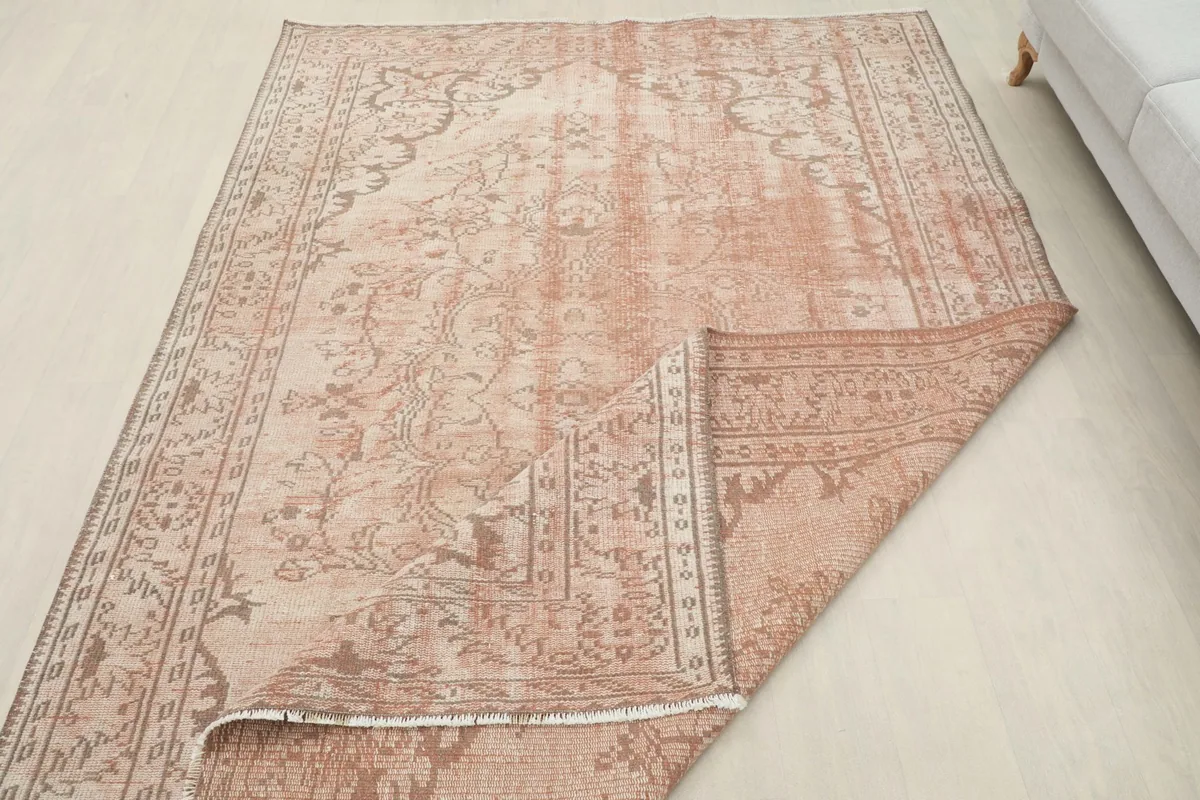 Rug partially folded to show the thickness and flexibility of the vintage textile