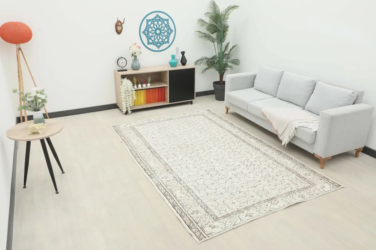Vintage ivory rug displayed in a bright living room setting with a sofa and side table