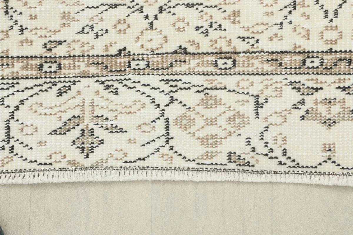 Detail of the rug's border and fringe, showing the craftsmanship and natural fiber ends