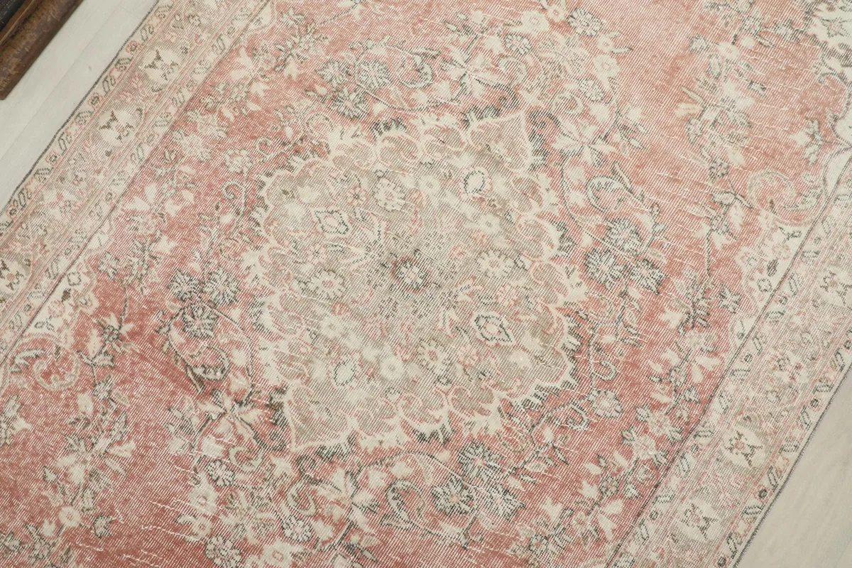 Detailed view of the central medallion and surrounding floral motifs with natural wear