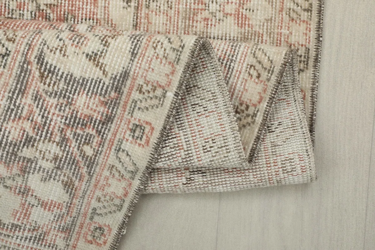 Folded edge of the rug revealing the thickness and the cotton foundation underneath