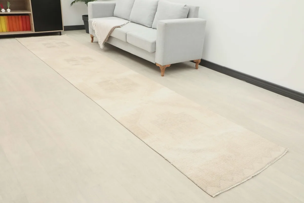 Angled view of the runner rug in a room setting, highlighting its muted tones and length.