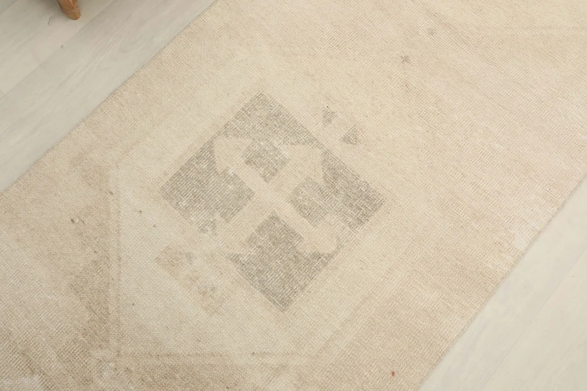 Angled close-up showing the texture and faded details of a central geometric design.