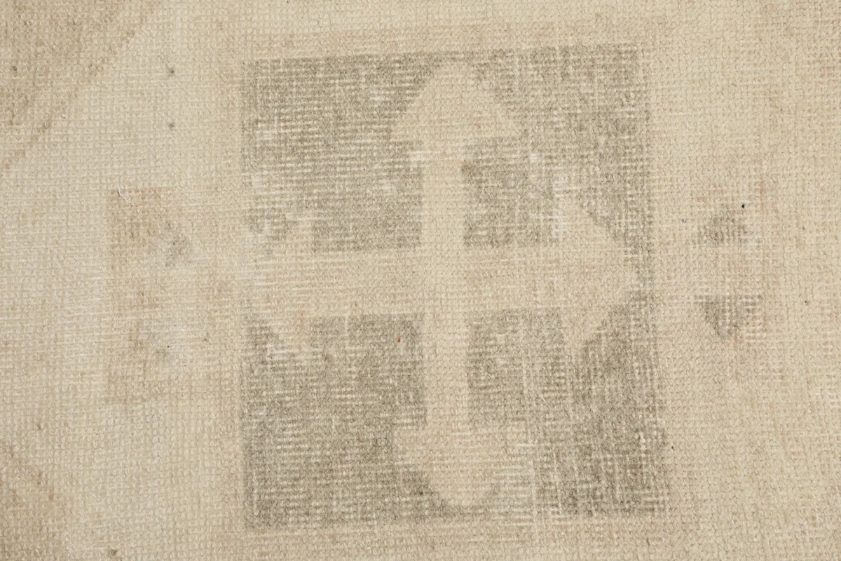 Extreme close-up of a geometric motif, revealing the hand-knotted wool pile and weave.